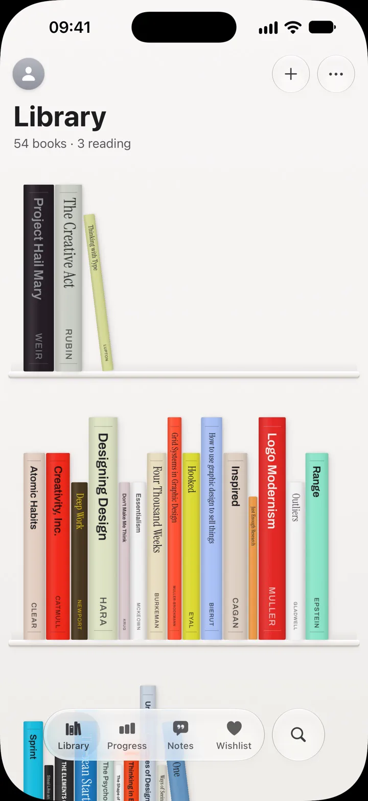A bookcase of book spines on thin white shelves, each spine in its cover’s colours.